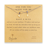 one for you one for me make a wish necklace set with gold dipped angel wings on ocean